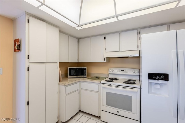 kitchen with white appliances, light tile patterned floors, and white cabinetry