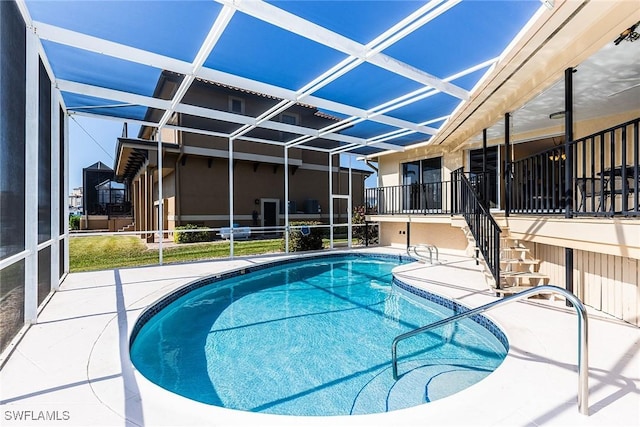 view of pool with a patio and glass enclosure