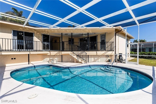 view of swimming pool featuring glass enclosure and a patio area