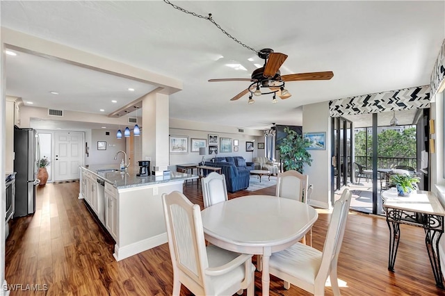 dining room featuring ceiling fan, sink, and hardwood / wood-style flooring