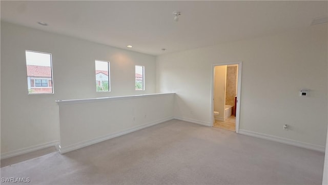 spare room featuring light colored carpet