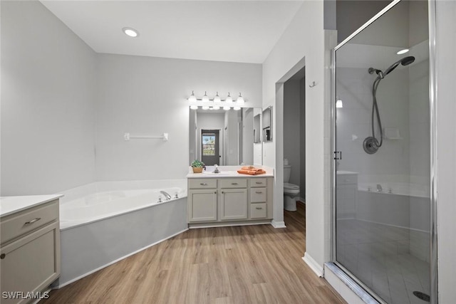 full bathroom with vanity, hardwood / wood-style flooring, independent shower and bath, and toilet