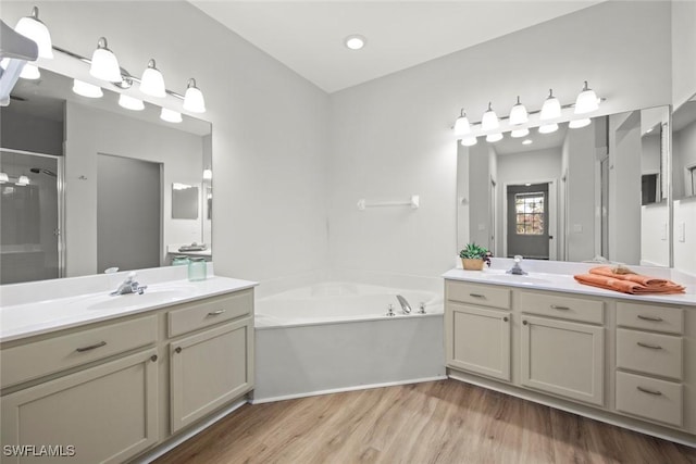 bathroom featuring hardwood / wood-style flooring, vanity, and separate shower and tub