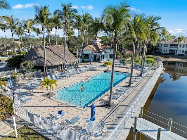 view of swimming pool featuring a patio and a water view