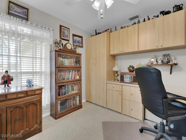 office space featuring light carpet and ceiling fan