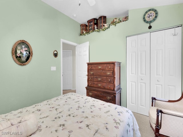 bedroom with a closet, a ceiling fan, vaulted ceiling, and carpet