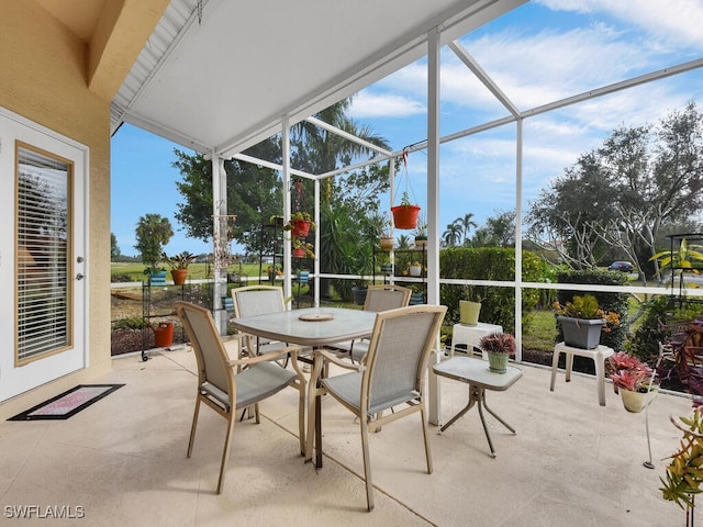 view of patio featuring outdoor dining area and glass enclosure