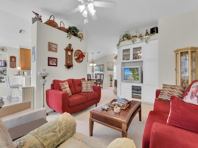 living room featuring visible vents, light carpet, vaulted ceiling, and ceiling fan