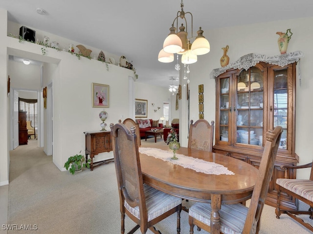 dining space with an inviting chandelier and light colored carpet