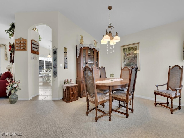 dining space with an inviting chandelier, light carpet, baseboards, and vaulted ceiling