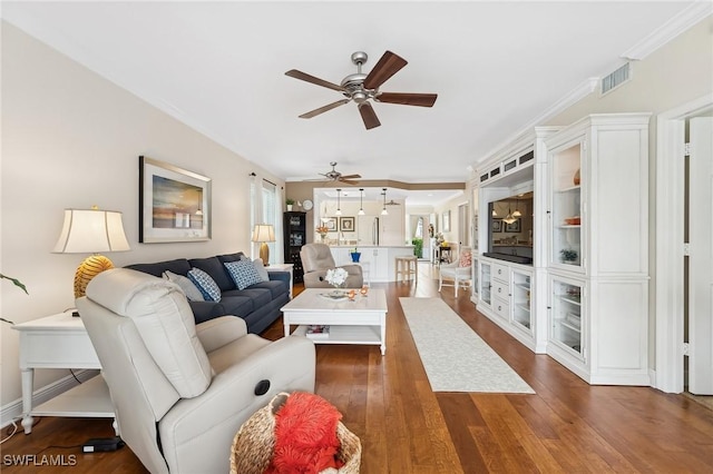 living room featuring ceiling fan, crown molding, and dark wood-type flooring