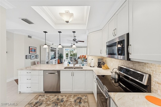 kitchen featuring appliances with stainless steel finishes, white cabinetry, kitchen peninsula, and sink