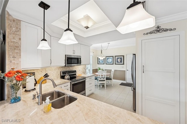 kitchen featuring sink, stainless steel appliances, white cabinets, and pendant lighting