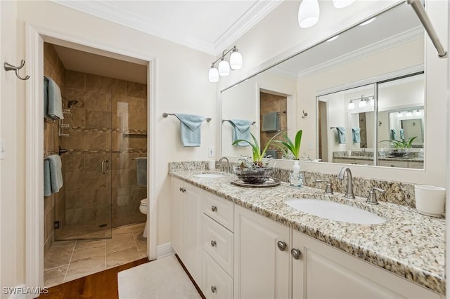 bathroom with wood-type flooring, toilet, crown molding, vanity, and an enclosed shower