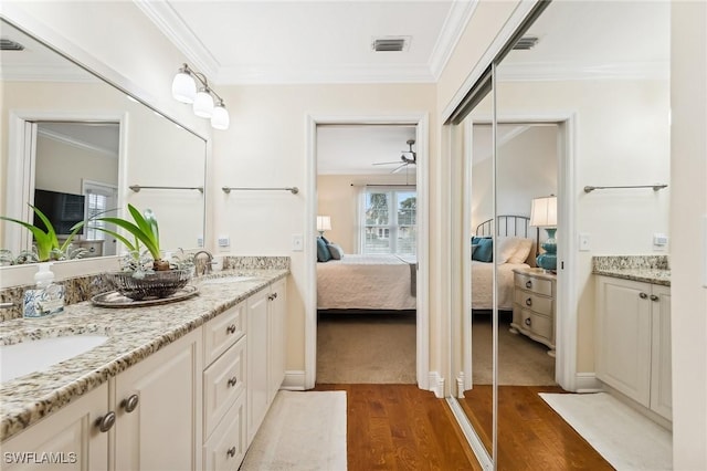 bathroom with hardwood / wood-style flooring, ceiling fan, crown molding, and vanity