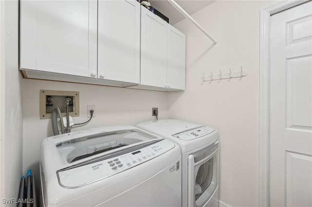 washroom featuring independent washer and dryer and cabinets