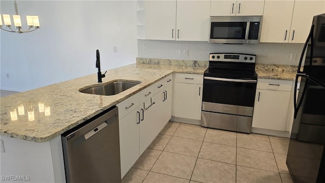 kitchen with stainless steel appliances, kitchen peninsula, light tile patterned floors, pendant lighting, and sink