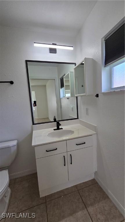 bathroom featuring tile patterned floors, vanity, and toilet