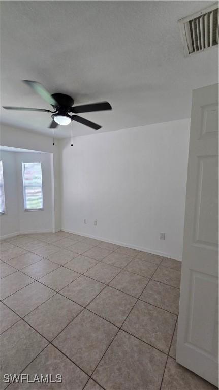 spare room featuring ceiling fan and light tile patterned floors