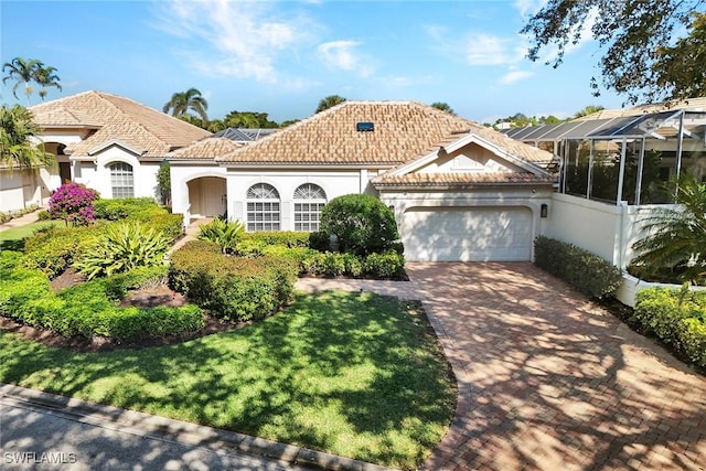 mediterranean / spanish house featuring a lanai, a front lawn, and a garage