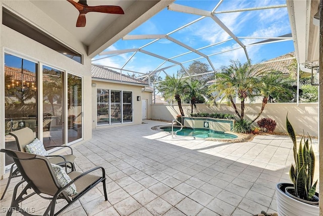 view of patio featuring ceiling fan, a hot tub, and glass enclosure