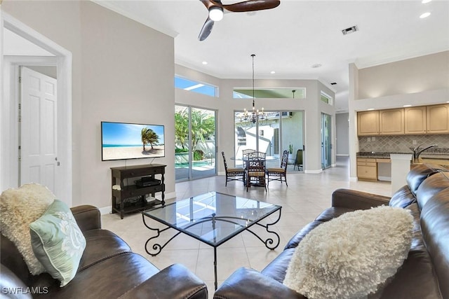 tiled living room with ceiling fan with notable chandelier, ornamental molding, and sink