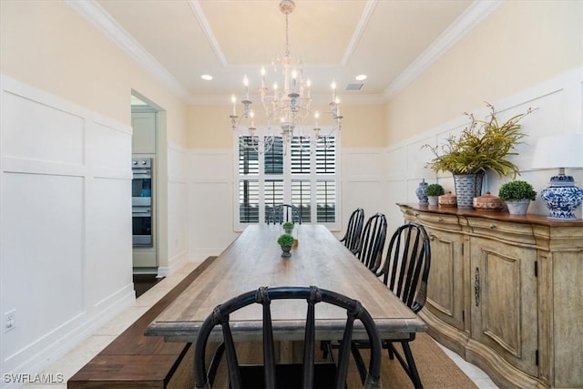 dining area featuring a notable chandelier, a raised ceiling, and crown molding