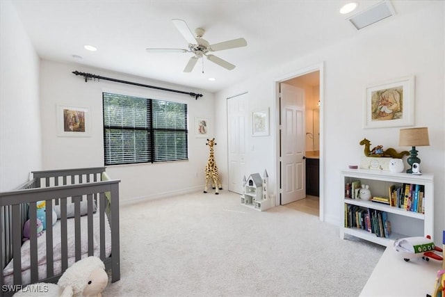 bedroom featuring ensuite bathroom, ceiling fan, a closet, a nursery area, and light colored carpet