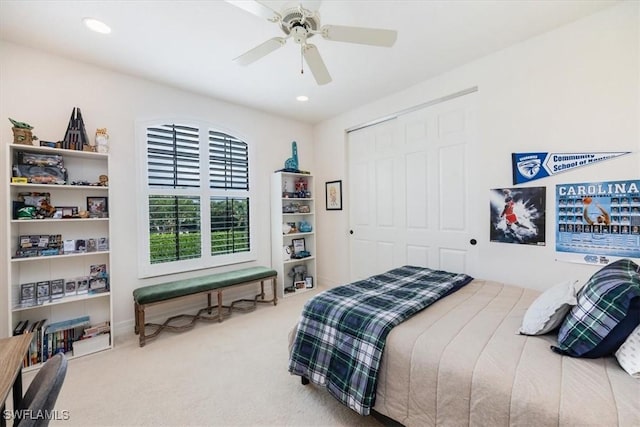 carpeted bedroom with ceiling fan and a closet