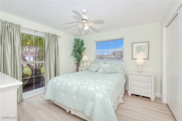 bedroom with ceiling fan, a closet, and light hardwood / wood-style floors