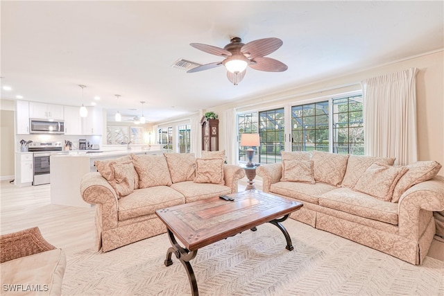 living room featuring ceiling fan and a wealth of natural light