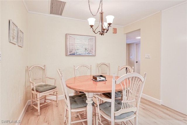 dining area with light hardwood / wood-style floors, crown molding, and a notable chandelier