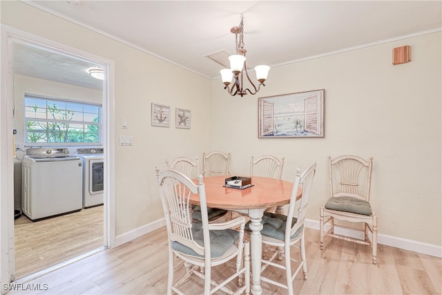 dining space featuring a chandelier, light wood-type flooring, washing machine and clothes dryer, and ornamental molding