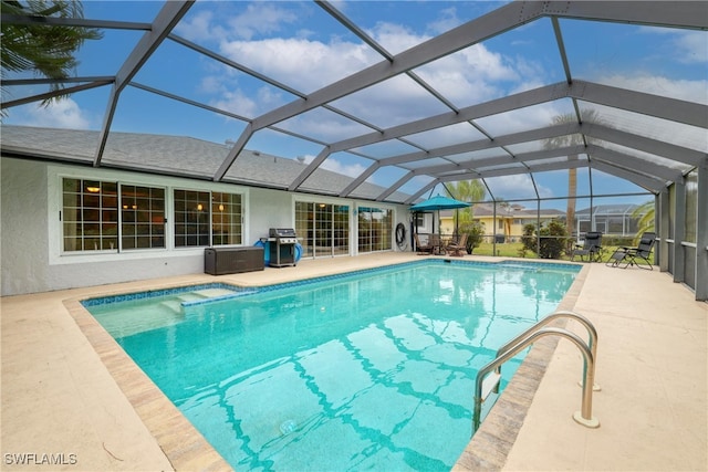 view of swimming pool featuring glass enclosure, area for grilling, and a patio area