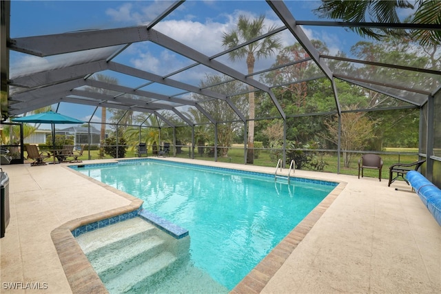 view of pool featuring glass enclosure and a patio area