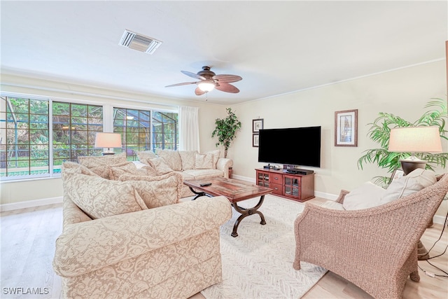 living room with ceiling fan, light hardwood / wood-style flooring, and ornamental molding