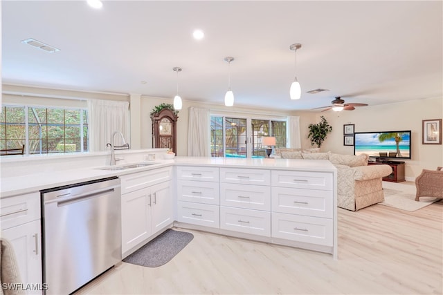 kitchen featuring decorative light fixtures, sink, white cabinetry, and stainless steel dishwasher