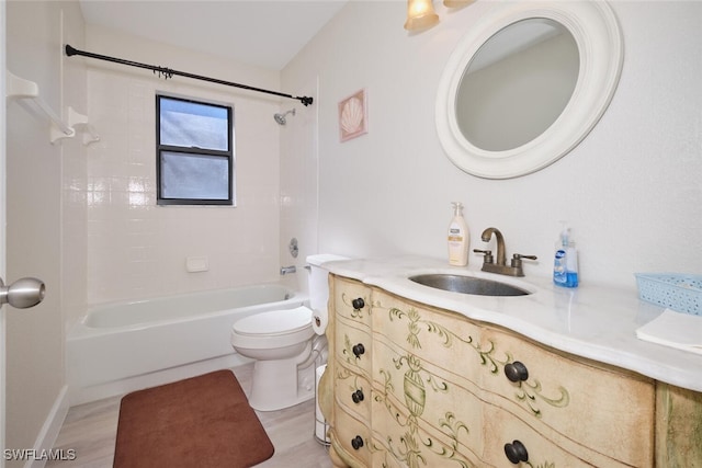 full bathroom with toilet, tiled shower / bath, hardwood / wood-style flooring, and vanity