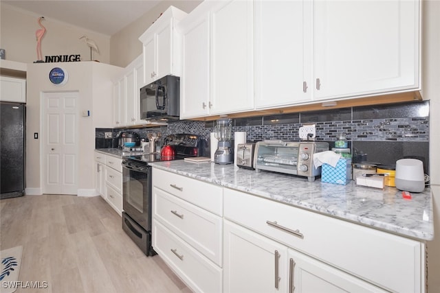 kitchen featuring decorative backsplash, light wood-type flooring, white cabinets, light stone counters, and black appliances