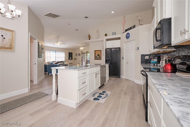 kitchen with black appliances, white cabinetry, sink, a kitchen island with sink, and light stone counters