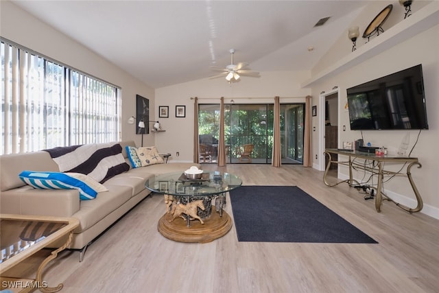 living room featuring ceiling fan, vaulted ceiling, a wealth of natural light, and light hardwood / wood-style flooring