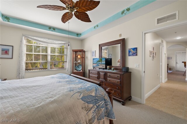 bedroom with light tile patterned floors, baseboards, visible vents, arched walkways, and light colored carpet