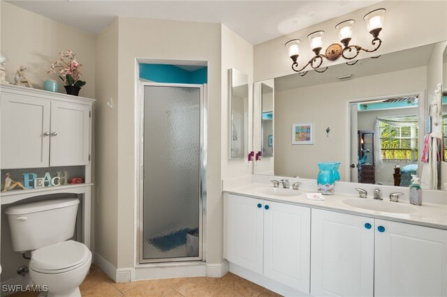 bathroom with a sink, a shower stall, toilet, and tile patterned floors