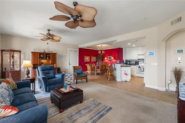 living area with light carpet, light tile patterned floors, visible vents, arched walkways, and ceiling fan