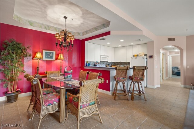 dining room with arched walkways, light tile patterned flooring, visible vents, and a notable chandelier