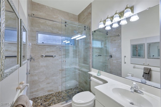 bathroom with a shower with shower door, toilet, and vanity