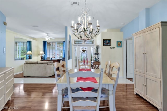 dining space featuring ceiling fan with notable chandelier and dark hardwood / wood-style flooring