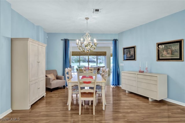 dining room with hardwood / wood-style floors and a notable chandelier