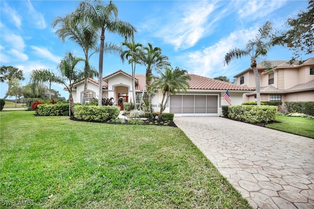 mediterranean / spanish home featuring a front yard and a garage