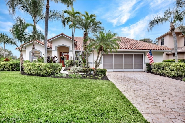 mediterranean / spanish home featuring a front yard and a garage